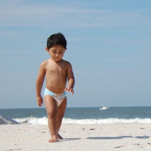 zwemluier kindje op strand met zwemluier aan